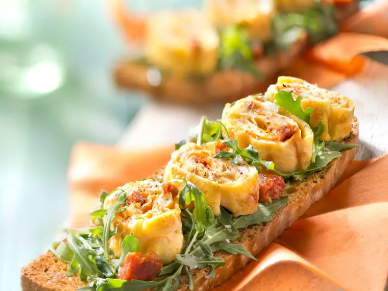 Omelettröllchen mit Rucola auf Röstbrot