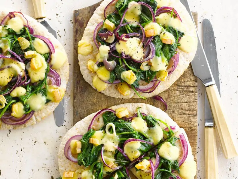 Käsepizza mit roten Zwiebeln und Spinat