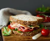 Belegtes Sandwich mit Käse, Schinken, Tomaten und Salat