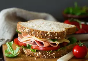 Belegtes Sandwich mit Käse, Schinken, Tomaten und Salat