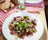Hirschcarpaccio mit Rucola, Parmesan und Champignons