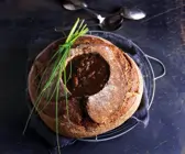 Zwiebelsuppe im Brot serviert