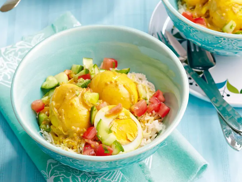 Gekochte Eier mit Curry-Kokos-Sauce auf Reis