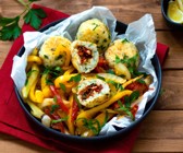 Paella-Reis-Bällchen gefüllt mit Tomaten auf mediterranem Gemüse