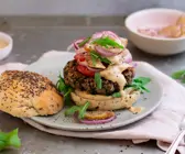 Burger mit Zwiebeln und Birne und nebenliegendem Deckel