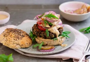 Burger mit Zwiebeln und Birne und nebenliegendem Deckel