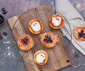 Mini-Pizzen mit Mozzarella und Oliven auf einem Kuchengitter