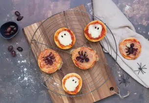 Mini-Pizzen mit Mozzarella und Oliven auf einem Kuchengitter