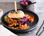 Pulled Jackfruit Burger mit Rotkohlsalat auf grauem Grund