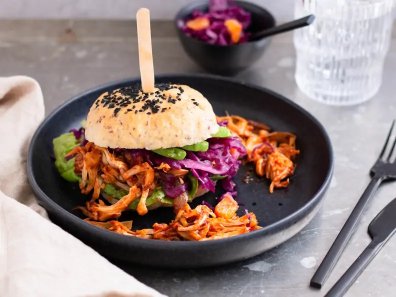 Pulled Jackfruit Burger mit Rotkohlsalat auf grauem Grund