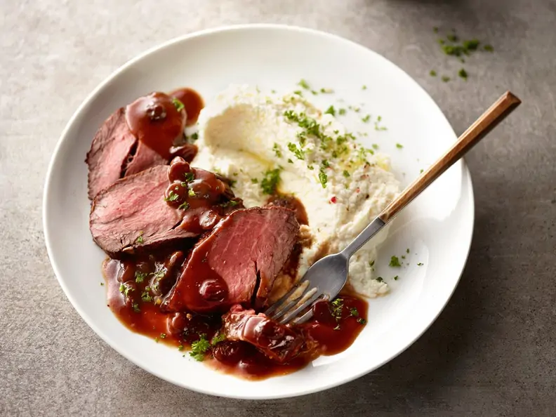 Sauerbraten in Scheiben geschnitten auf Teller mit Sauce