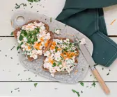 Zwei Brotscheiben mit weißem Frischkäse liegen auf einem Brett