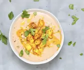 Schale mit Maronensuppe, Birnenwürfel und Nüssen als Topping und gehackter Petersilie