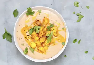 Schale mit Maronensuppe, Birnenwürfel und Nüssen als Topping und gehackter Petersilie