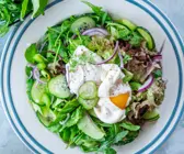 Blattsalat mit Gurken und pochiertem Ei