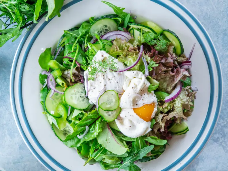 Blattsalat mit Gurken und pochiertem Ei