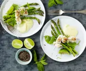 Fischspieße auf grünem Spargel mit Limettensauce