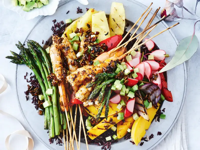 Garnelenspieße mit Spargel, Obst und schwarzem Reis