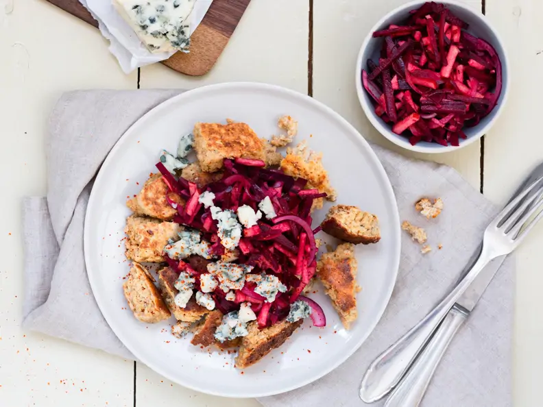 Kaiserschmarrn auf hellem Teller getopped mit Rote-Bete-Salat und Roquefort