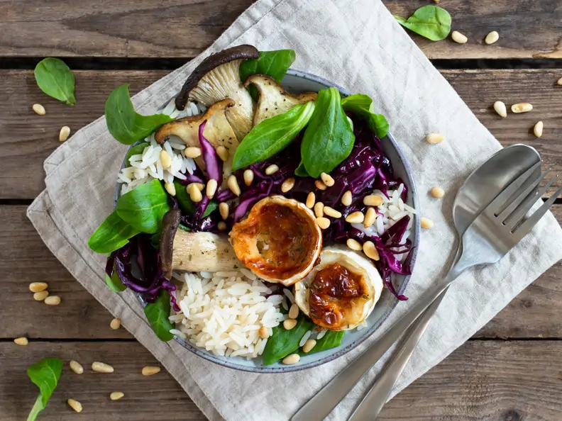 Reis-Bowl mit Rotkohlsalat, Feldsalat, Kräuterseitlingen und gebackenem Ziegenkäse