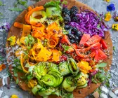 Bunter Regenbogensalat auf einem Holzbrett