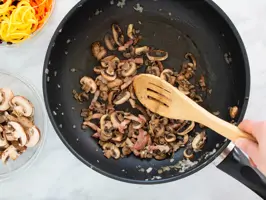 Pilze und Zwiebeln werden in einer Pfanne angebraten