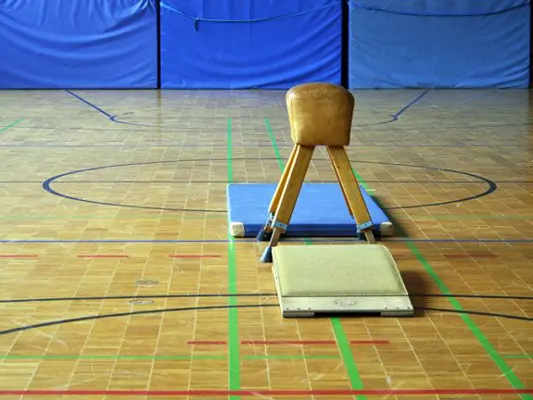 Bock und Sprungbrett in einer leeren Turnhalle 