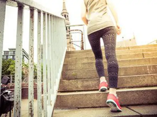 Gut trainierte Frau springt eine Treppe hinauf 