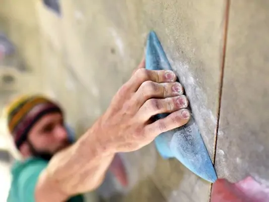 Mann beim Bouldern in einer Kletterhalle 