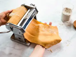 Teig wird durch eine Nudelmaschine gegeben