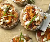 Kleine, runde Pizzen auf einem mit Backpapier ausgelegtem Blech