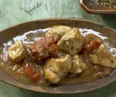 Indisches Hähnchen-Curry auf einem braunen Teller