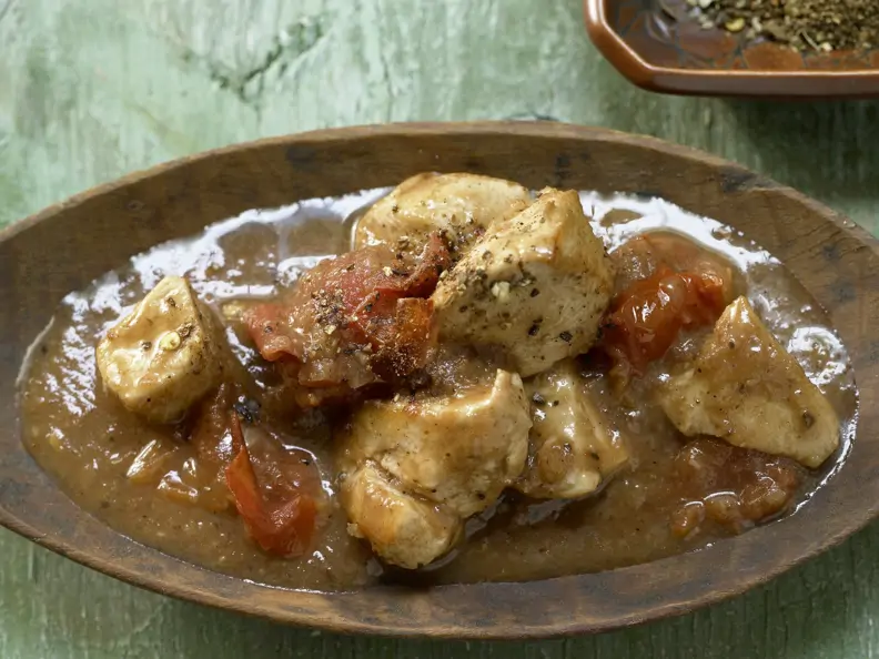Indisches Hähnchen-Curry auf einem braunen Teller