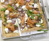 Pizza mit Räucherlachs auf einem Blech