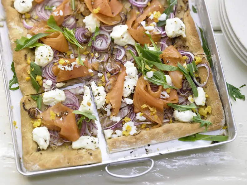 Pizza mit Räucherlachs auf einem Blech