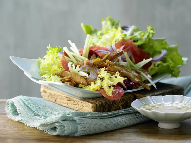 Putenstreifen auf buntem Salat