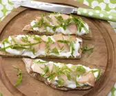 Geschnittene Pizza auf einem Holzbrett mit einem Messer 