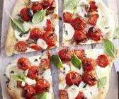Pizza mit Tomaten, Mozzarella und Basilikum