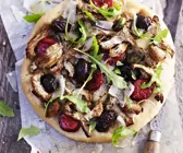 Pizza mit Artischocken, schwarzen Oliven, Rucola und scharfer Wurst (Chorizo)