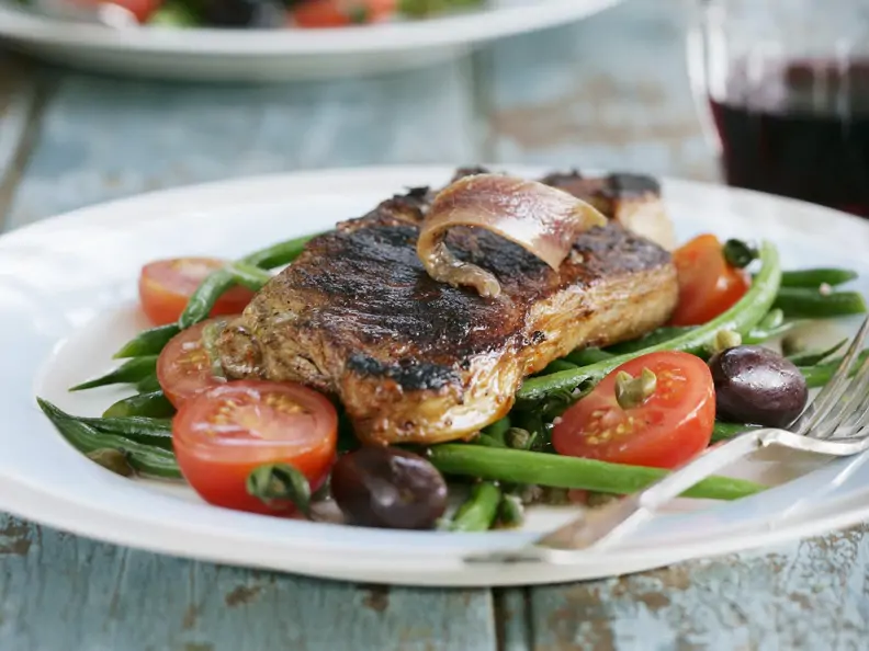 Steak vom Rind mit Sardellen, grünen Bohnen, Oliven und Tomaten