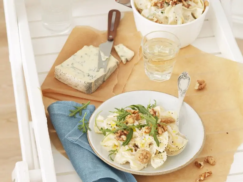 Pasta mit Gorgonzola-Walnuss-Soß neben Gorgonzola und Wasserglas