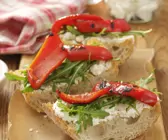 Italienisches Weißbrot (Ciabatta) mit Ziegenkäse, Rauke und Paprika vom Grill