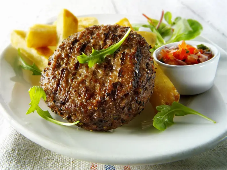 Rinderhacksteak mit Salat und Pommes