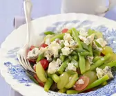 Grüner Bohnensalat mit pikantem Käse und Trauben auf Teller 