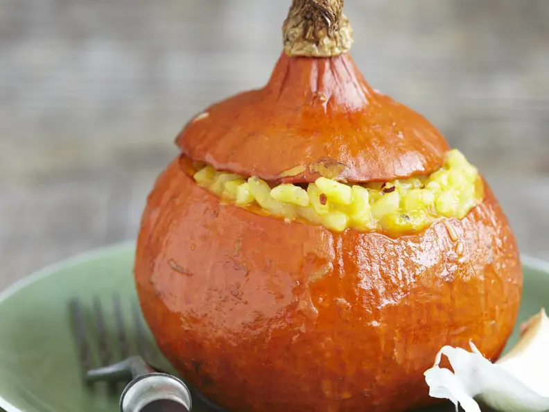 Ausgehöhlter Kürbis mit Risotto gefüllt