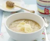 Haferbrei mit Banane und Honig in weißer Schale