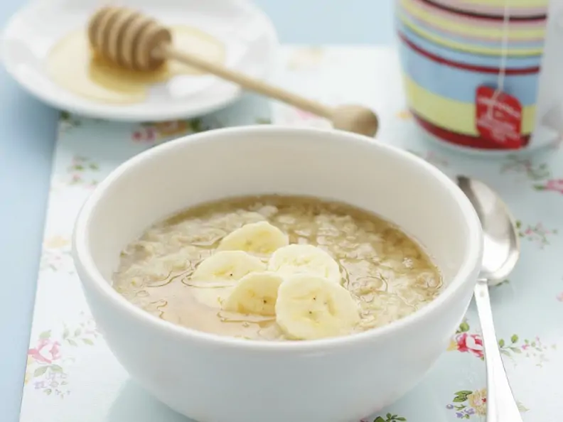Haferbrei mit Banane und Honig in weißer Schale