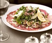 Rindfleisch-Carpaccio mit Artischocken, Rucola, Parmesan und Trüffel