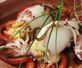 Tintenfischtuben mit Fischfüllung auf Tomatenscheiben