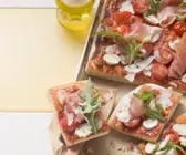 Pizza mit Kirschtomaten und Parmaschinken